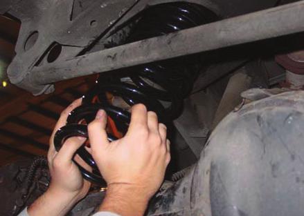 2. INSTALL COIL SPRING INTO REAR SUSPENSION. ALIGN THE UPPER ALUMINUM SPRING MOUNT IN PLACE.