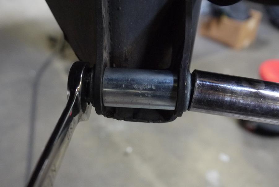 Line up the rear shock mount bolt holes by using a tapered punch to align the holes and slip a bolt through the bracket and OEM shock tabs and spacer on the rear axle.