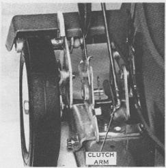 With the clutch arm resting on the handle and wheel bracket as shown.