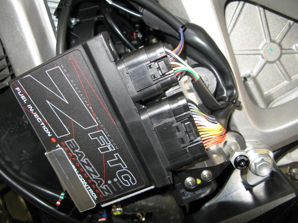 Remove the mounting hardware and install the Bazzaz control unit mounting bracket over the throttle control unit. Secure by reinstalling the existing hardware.
