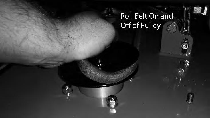) While lifting up on the belt (as shown in the photograph), rotate the pulley until the belt is free of the pulley.