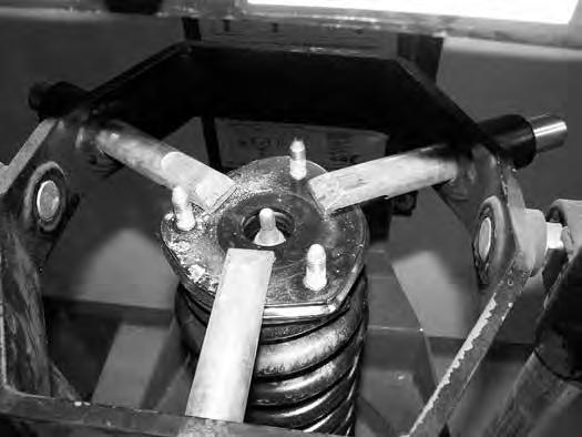 Coil spring is under extreme pressure. Improper removal/installation of coil spring could result in serious injury or death.