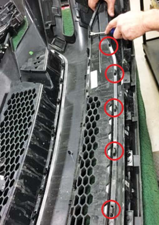 12. Remove the OEM lower grill by prying back on twenty-two (22)