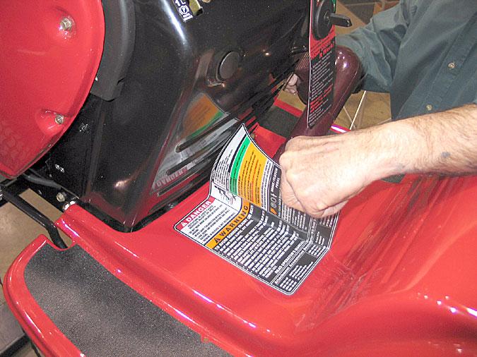 6.8. Using a heat gun, carefully heat the warning label and peel it from the fender panel. Set it aside to be re-installed during assembly. See Figure 23. 6.11.