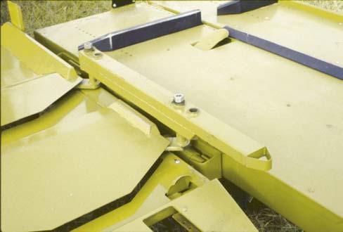 When the switch is depressed, the latch holding the side cart up disengages, the weight of the bale(s) tilts the side cart back, and the bale(s) slide onto the ground.
