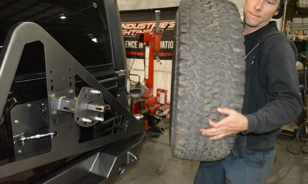 Lift the spare tire onto the Tire Mount - Tire Side, and fit the previously installed lug studs through the holes in the wheel. Tighten the (3) Lug Nuts.