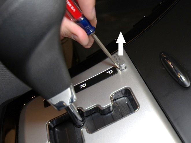 Depress the parking brake and remove the shift lock cover with a small flat