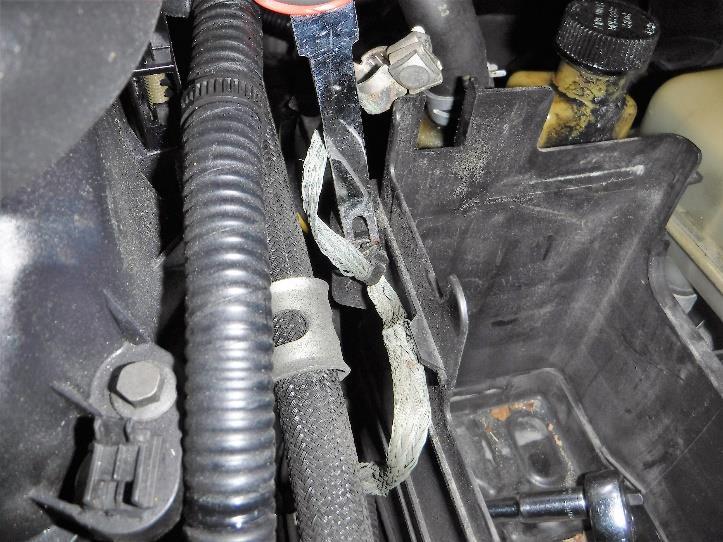 Remove the ground strap fitting that is attached to the battery box using a fork tool or screwdriver as shown in Photo 3-3.