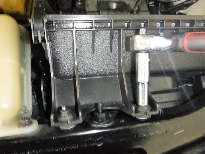 Once the ECU is removed you will have access to removing the radiator cover. Remove the ground strap using a 10 mm wrench as shown in Photo 1-9.