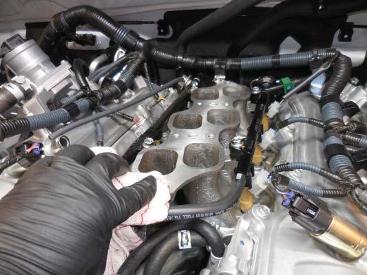 The engine is shown with the manifold removed. Clean intake port areas with a clean dry rag.