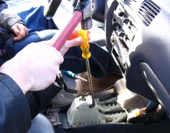 Use a flat head screwdriver and a hammer to pry the clip on the passenger side of the assembly off of the