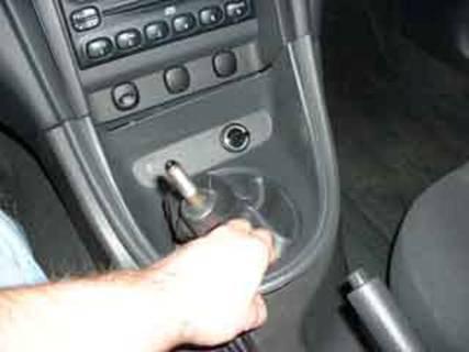 Pull the cover off the shifter and unplug the cigarette lighter plug.