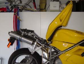 3. There are several methods to support the bike. The main problem in supporting the bike for this operation is to keep the front tire from lifting off the ground instead of the rear of the bike. a. Rear stand, using tiedowns to support tail section from ceiling joists/rafters.