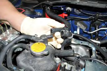 Using pliers remove the OEM upper coolant expansion tank hose clamp.