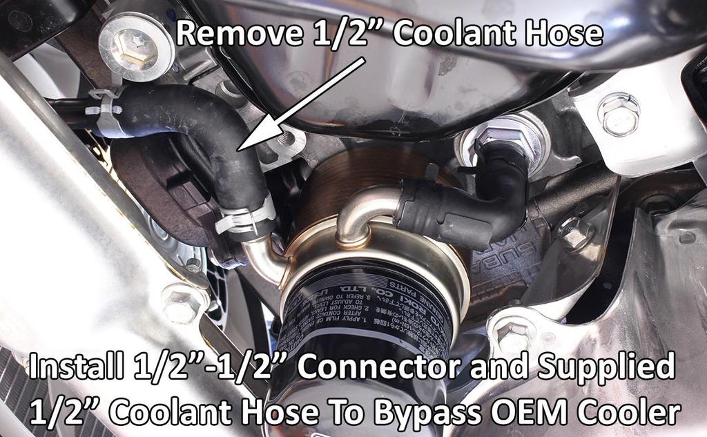 7. These next few steps should be done quickly to reduce the amount of coolant lost. a. Prepare to bypass OEM oil cooler and catch some amount of coolant. You will reuse two OEM pinch clamps. b. Locate coolant hose as shown and disconnect from metal pipe going toward front of car.
