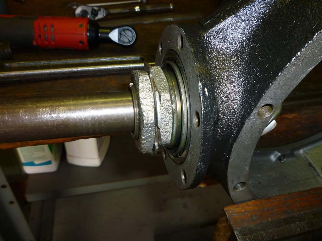 With the banjo in a horizontal position in a wood vice the drive shaft with locking key is inserted into the pinion gear sleeve. I always coat the taper on the drive shaft with antiseize compound.