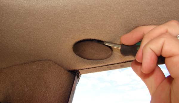 The lock nuts are accessed via plastic caps inserted in the ceiling upholstery. Figure 6-1 shows the plastic caps on the left side of the cab. Locate the four plastic caps.