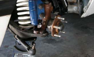 Place a floor jack under the control arm near the ball joint.