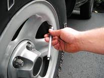 b) Place the end of the tire gauge over valve.