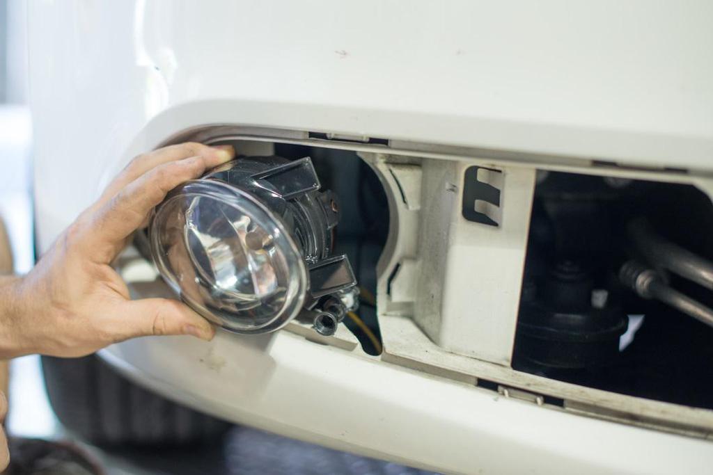 7. Install the fog light by inserting the two locating tabs into the slots in the