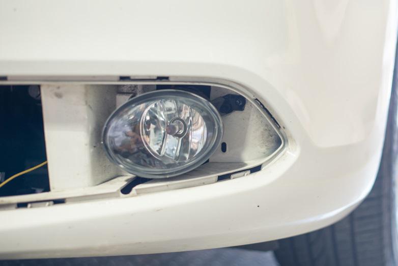 11. Install the fog light by inserting the two locating tabs into the slots in the