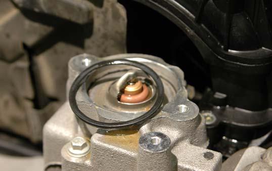 45. Remove the thermostat outlet and O-ring seal from the