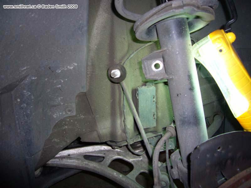 Remove the brake line and ABS sensor line from the clamp on the side of the strut.