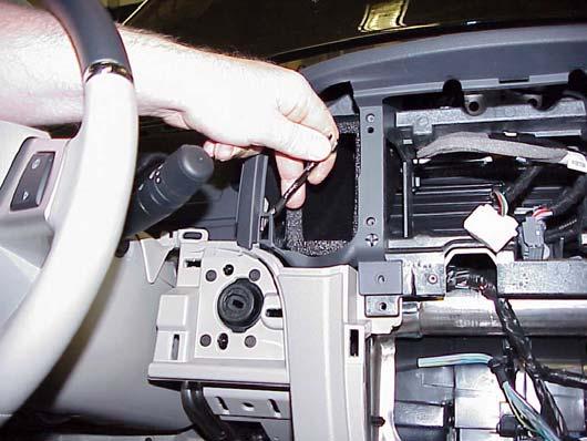 Remove the six top cover-to-instrument panel retaining screws and one bolt at the radio opening in the instrument panel (Figure 4). 19.