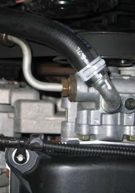 Rotate hose as shown, until the line is as close to the engine as possible. Tighten hose.