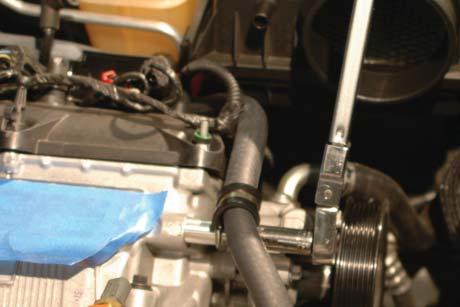 52. Use the provided spacer, Adel clamp, and bolt to anchor the heater hose to the bolt hole on the front of the driver side head.