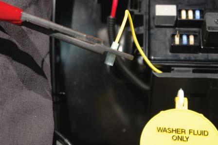 104. Open the fuse center cover and route the yellow wire up