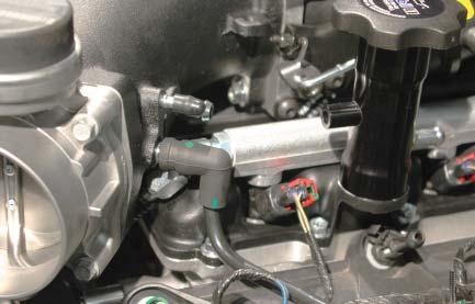 Plug the EVAP plastic tube on the driver side of the engine into the barb below the