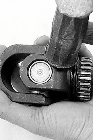 Remove the bearings by tapping the universal joint with a copper hammer.