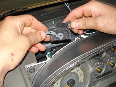 Disconnect the wire harness from the LH side of the gauge cluster by moving the connector lock lever to the left (see Figure 6).