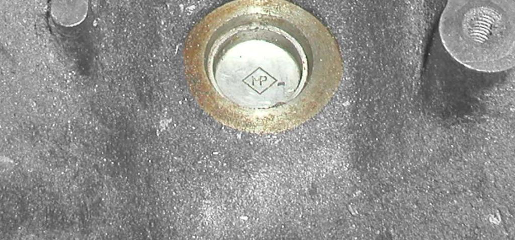 Using a hammer and small drift, lightly tap on the edge of this freeze plug to spin it out of place.