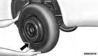 8. Position the spare wheel/tire on the vehicle and install the lug nuts with the cone-shaped end toward the wheel. Lightly tighten the nuts. CAUTION!