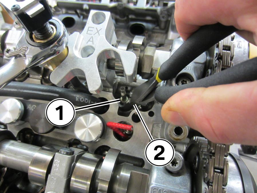28. Remove the valve seals (1) with the angled seal pliers (2) included in the tool kit. Repeat this process on the adjacent valve P/N AGA-VSPA 29.
