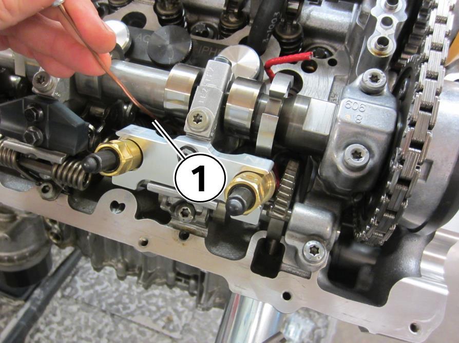 56. Rotate the compression nut counter clockwise with the ratchet (1) until the compression rod compresses the valve Hold the locator handle (2) firmly to keep the compression rod properly centered
