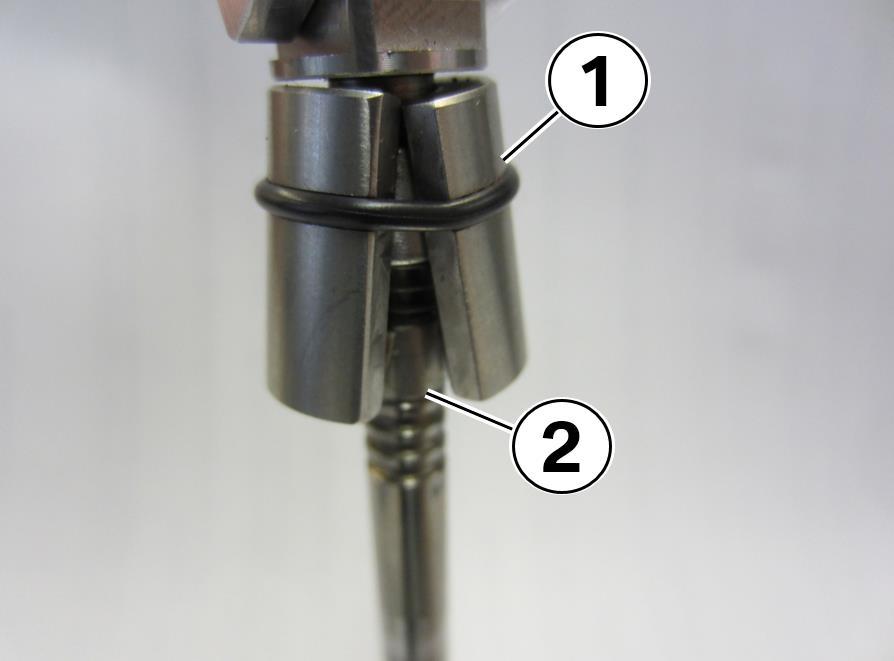 The end of the tool has a machined hole (1) to fit the top of the intake valve (2).