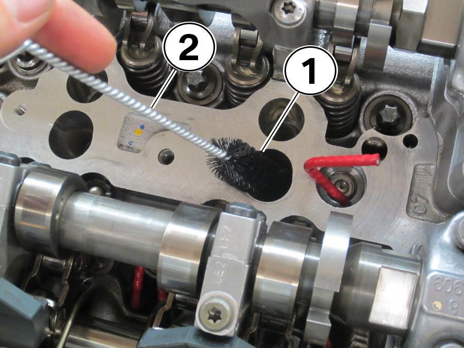 8. Gently clean the upper portion of the injector bores (1) with the brush (2)