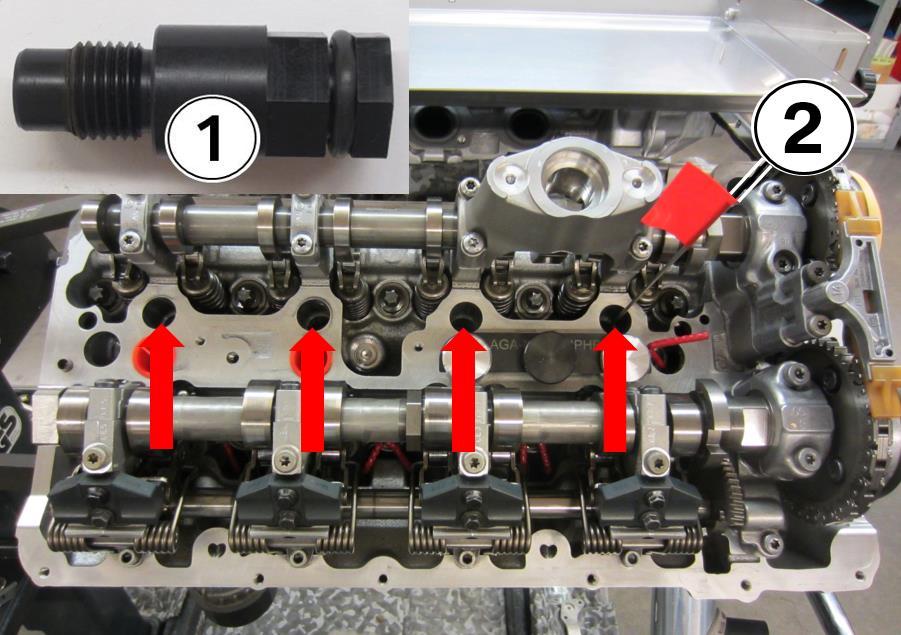 11. Screw four of the black plastic spark plug TDC tools (1) into each of the spark plug holes (see arrows) to avoid debris from falling into the cylinders.