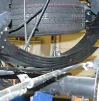 Note: Disconnect from in front of the OEM muffler & remove. Remove the OEM rear leaf spring. 9. Install the new Skyjacker rear spring on top of the OEM block.