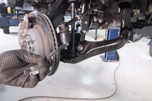 64. Reinstall the tie rod and tighten using a 21mm wrench. See Photo 54. 65.