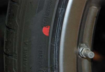A red paint mark or a yellow temporary tape strip on the tire indicates the point of the greatest tire runout.