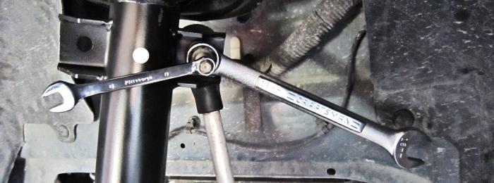 10. Using an 8mm box wrench to keep the end link stud from spinning, remove the end link nut using an 18mm box wrench. 11. Support the lower control arm and spindle with a jack and jack stand.