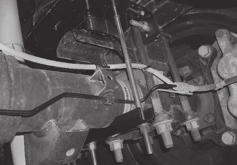 20 If the hard brake line is resting on the lower bracket carriage bolt on either side, push or pull the brake