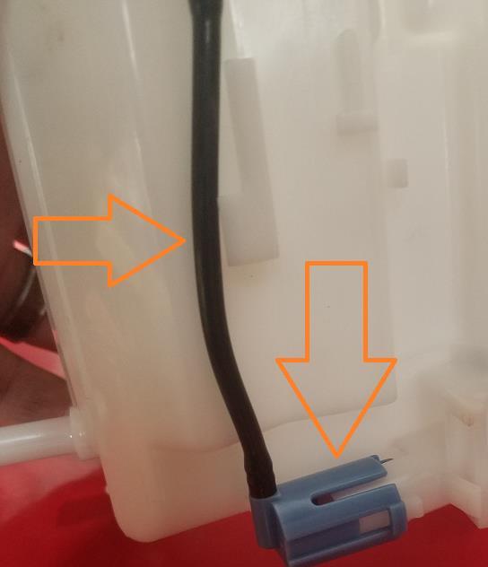 thin black hose under the plastic tab (below, right).