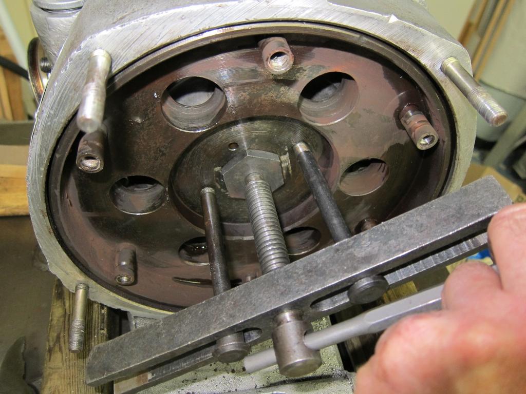 Flywheel Take a punch and flatten the safety washer under the flywheel bolt. Prevent the flywheel from turning (see Figure 4) and use a 36 mm socket wrench to loosen, but not remove, the bolt.