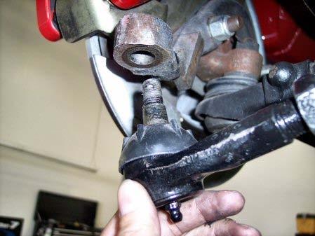 Use a 11/16 wrench to unfasten the tie rod end castle nut.