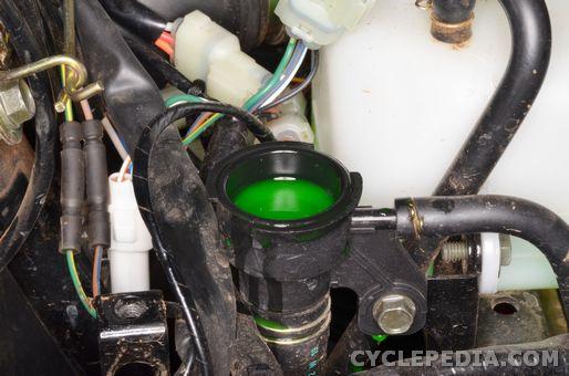 Slowly pour the new coolant into the radiator filler neck until it reaches the bottom of the neck. With the reservoir cap and the radiator cap off, start the engine and let it run for several minutes.